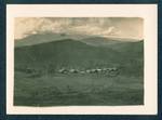 View of houses, with mountain ranges in background, Baiune, New Guinea, c1929 to 1932