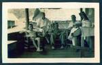 Group of men sitting on verandah, from left two unidentified men, Harry Jones and Eric Gaude, at Harry Jones house, Baiune, New Guinea, c1929 to 1932