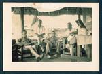 Group of men sitting on verandah, from left Bert Lee, unidentified man, Harry Jones and Eric Gaude, at Harry Jones house, Baiune, New Guinea, c1929 to 1932